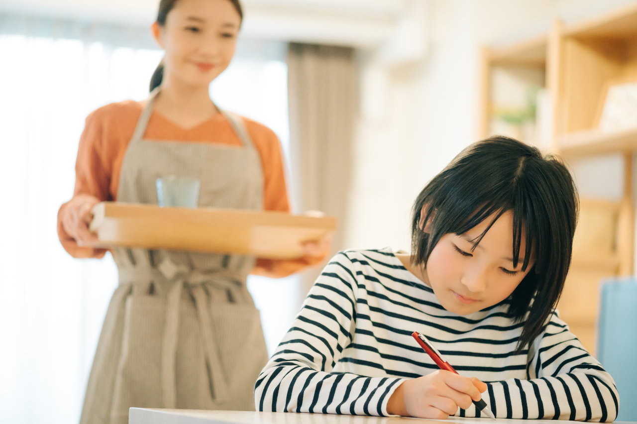 子どもの勉強を見守る母親とその子ども