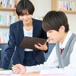 女性の講師と勉強に集中する男子中学生