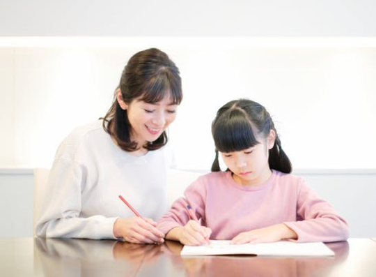 勉強する子供と教える大人
